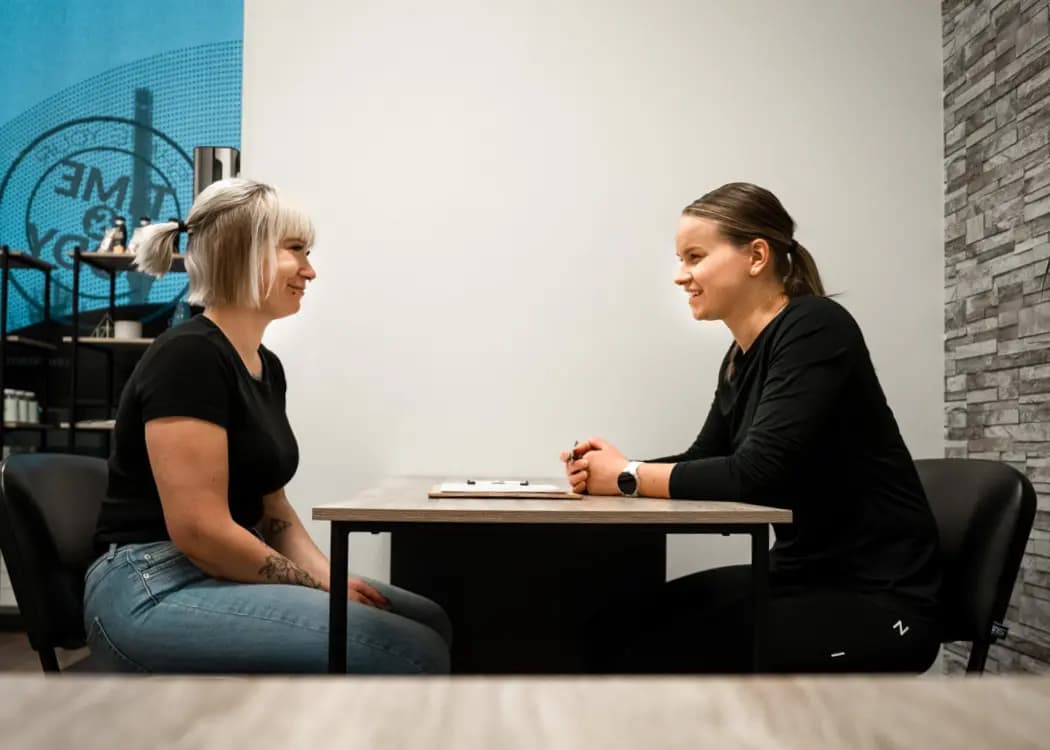 Valmentaja käy konsultaatiossa tuloksia läpi asiakkaan kanssa MyEMS-studiolla.